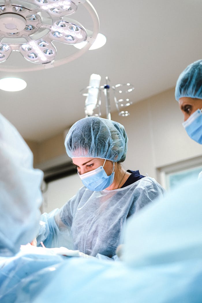 Home A team of surgeons and nurses in protective gear performing an operation in a hospital.