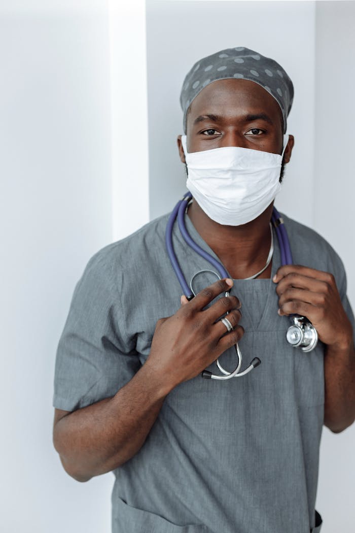 Home Portrait of a healthcare worker wearing a face mask and scrubs, demonstrating COVID-19 safety measures.